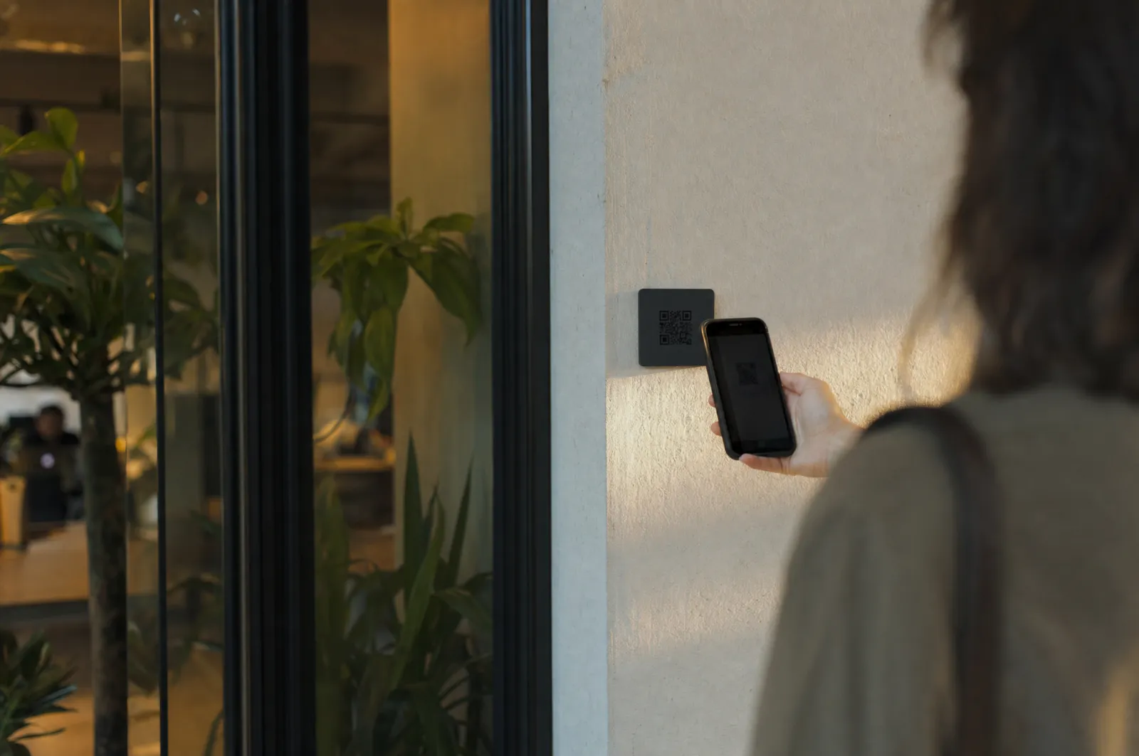 Eine Person scannt den Check-in-Code am Eingang eines Coworking-Space